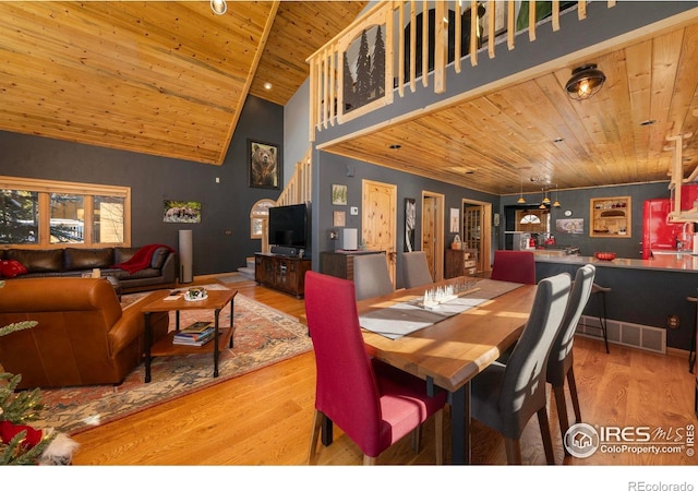 dining area featuring hardwood / wood-style floors, high vaulted ceiling, and wood ceiling