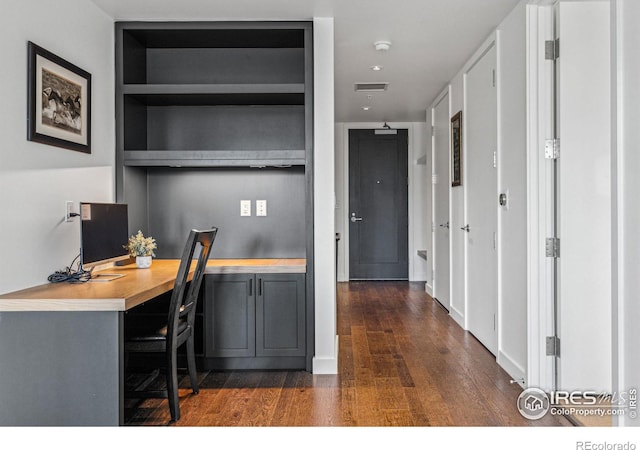 office space featuring built in desk and dark hardwood / wood-style floors