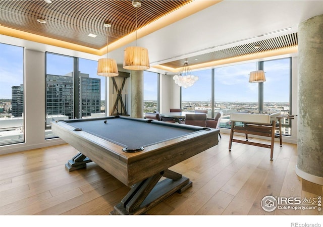 rec room featuring a raised ceiling, expansive windows, light wood-type flooring, wood ceiling, and pool table