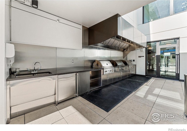 kitchen featuring decorative backsplash, sink, and wall chimney range hood