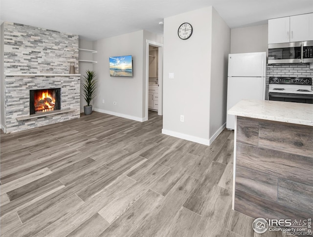 unfurnished living room featuring a fireplace and light hardwood / wood-style floors