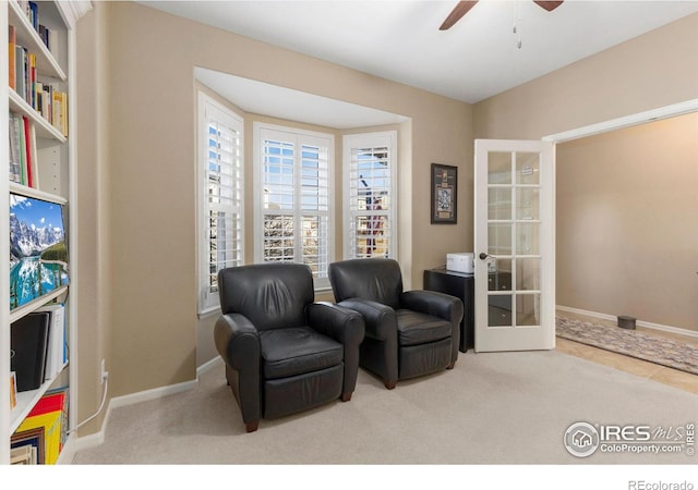 sitting room with carpet flooring, ceiling fan, and french doors