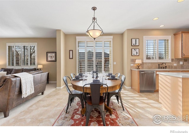 tiled dining area featuring plenty of natural light and sink