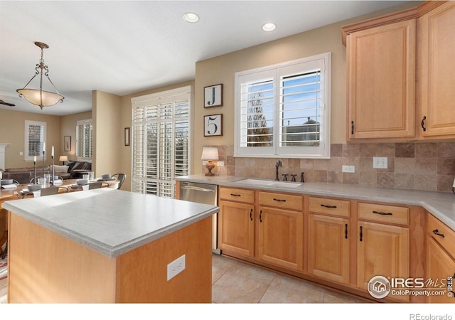 kitchen featuring light brown cabinets, sink, decorative backsplash, decorative light fixtures, and a kitchen island