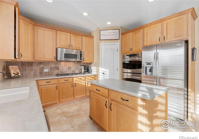 kitchen featuring light brown cabinetry, backsplash, stainless steel appliances, sink, and light tile patterned floors