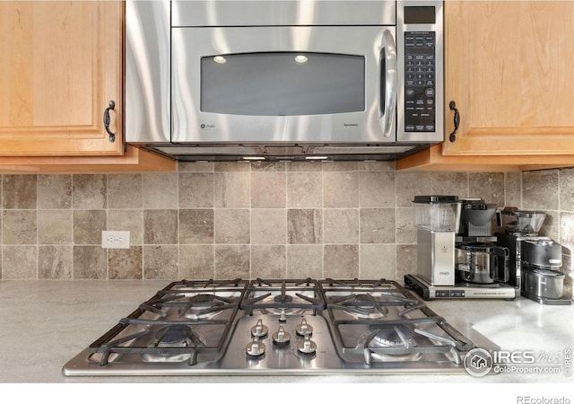 kitchen featuring tasteful backsplash, light brown cabinets, and appliances with stainless steel finishes