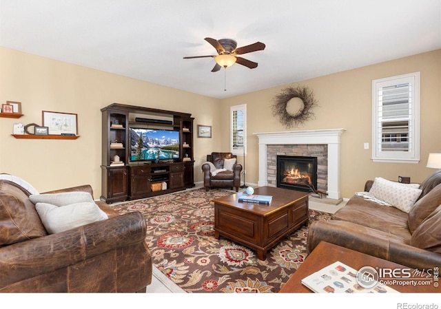 living room featuring a fireplace and ceiling fan