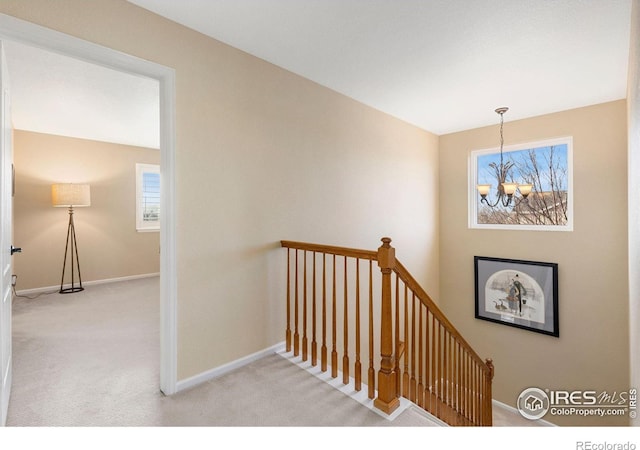 stairs featuring a chandelier and carpet floors