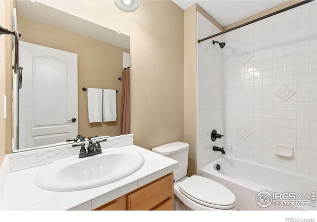 full bathroom featuring vanity, tiled shower / bath combo, and toilet