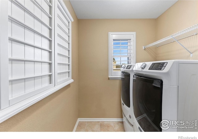 washroom with washer and clothes dryer and light tile patterned flooring