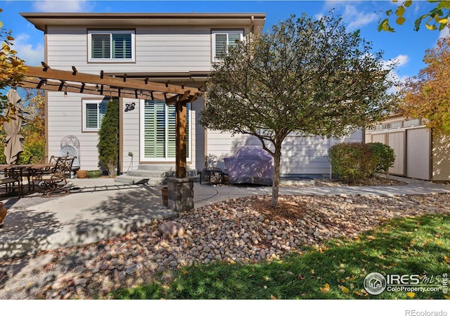 back of property featuring a pergola and a patio