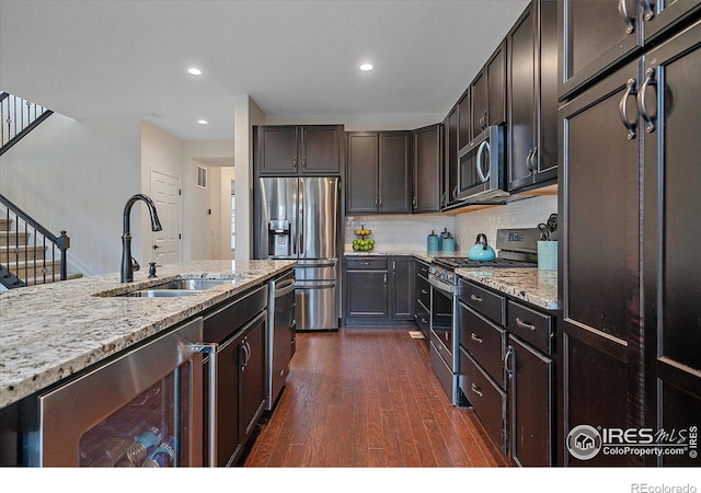 kitchen featuring backsplash, sink, dark hardwood / wood-style floors, dark brown cabinetry, and stainless steel appliances