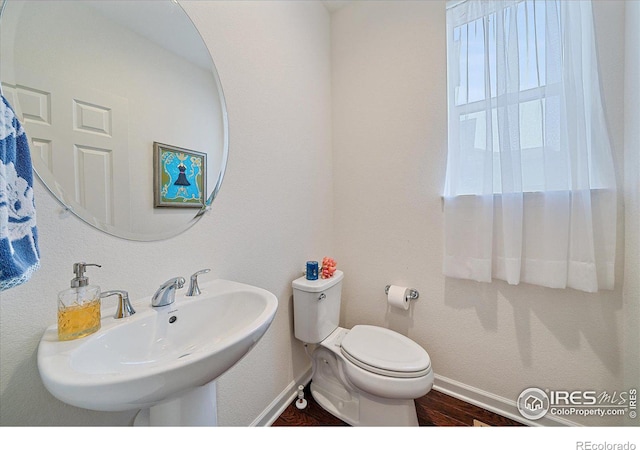 bathroom featuring hardwood / wood-style flooring, toilet, and sink