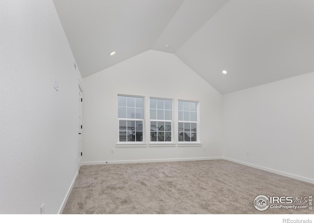 carpeted spare room featuring lofted ceiling