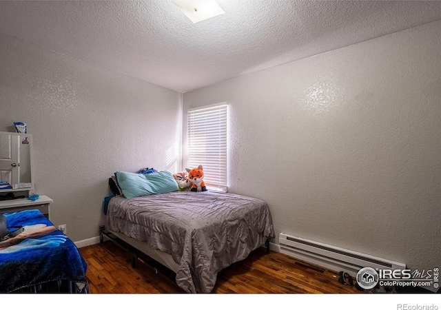 bedroom featuring dark hardwood / wood-style flooring, a textured ceiling, and a baseboard radiator