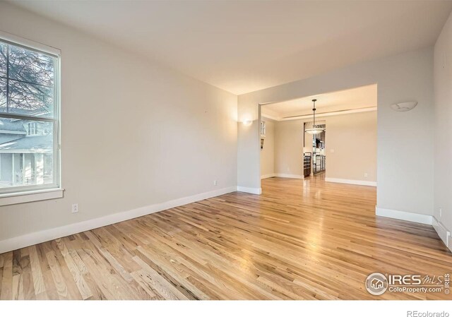 empty room with light wood-type flooring and baseboards