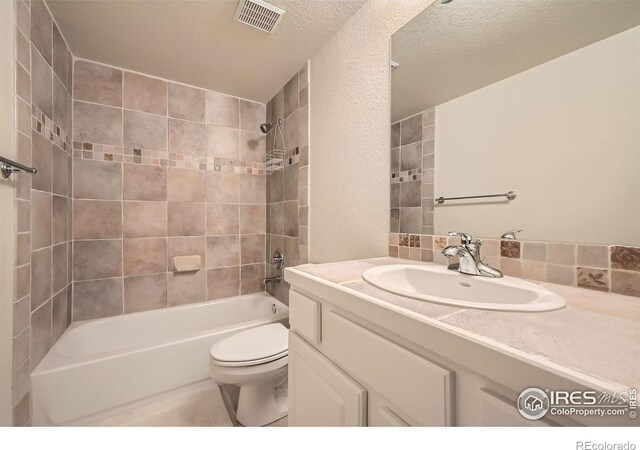 bathroom featuring vanity, shower / bath combination, visible vents, a textured ceiling, and toilet