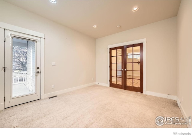 carpeted spare room featuring recessed lighting, visible vents, baseboards, and french doors