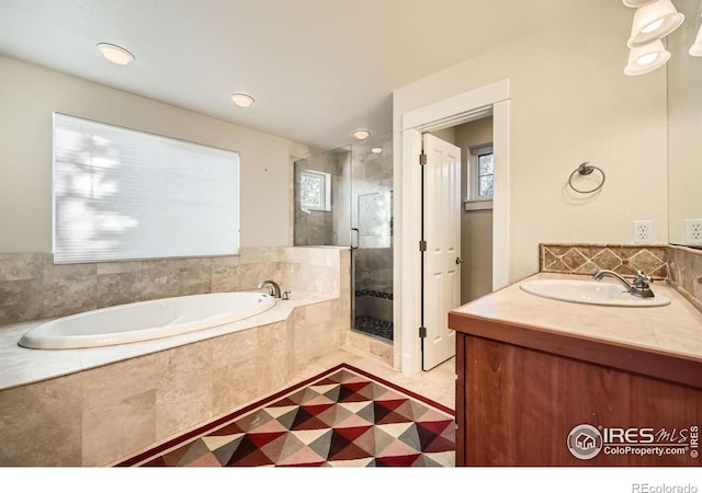 full bath with a wealth of natural light, a garden tub, a stall shower, and vanity