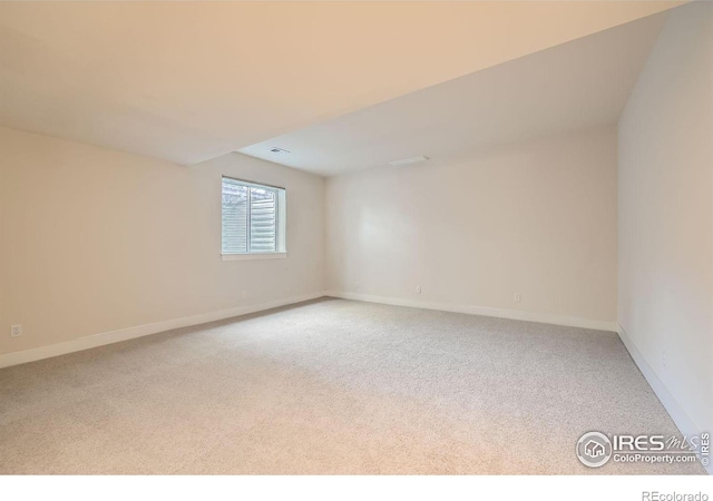 unfurnished room featuring visible vents, baseboards, and light colored carpet