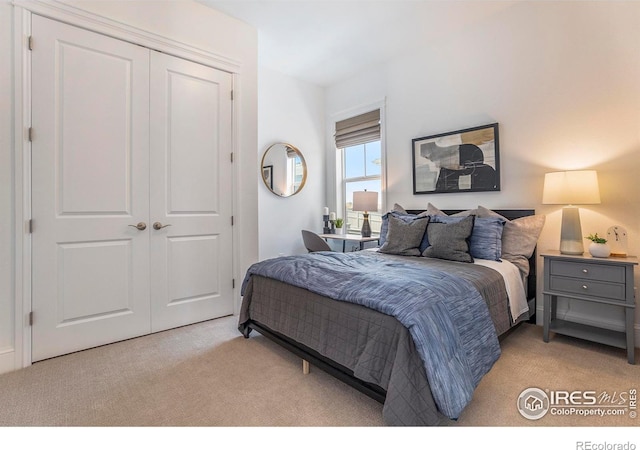 bedroom with light carpet and a closet