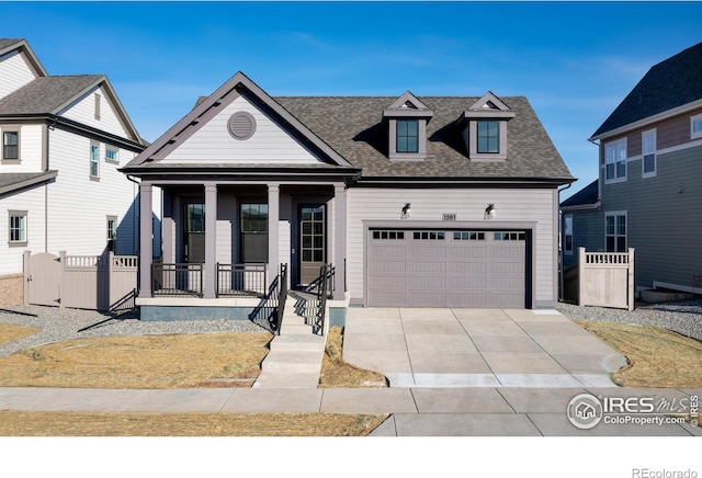 view of front facade featuring a porch, concrete driveway, fence, and an attached garage