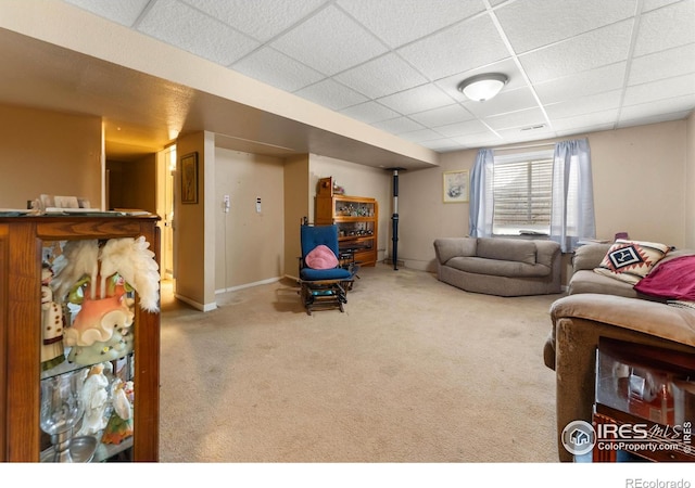 living room featuring carpet flooring and a drop ceiling