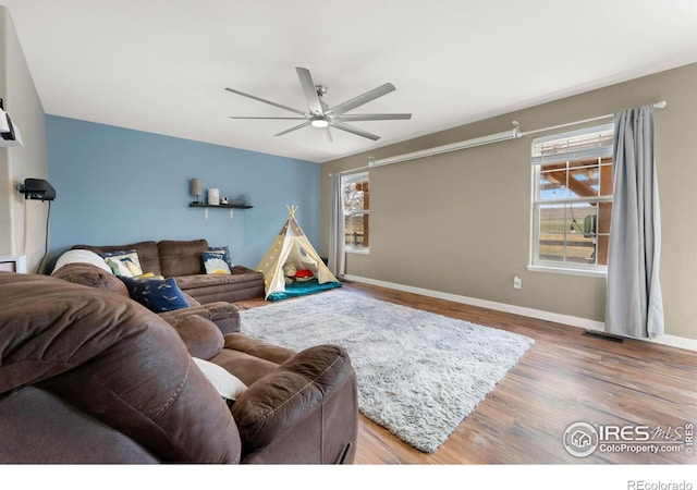 living room with ceiling fan and wood-type flooring