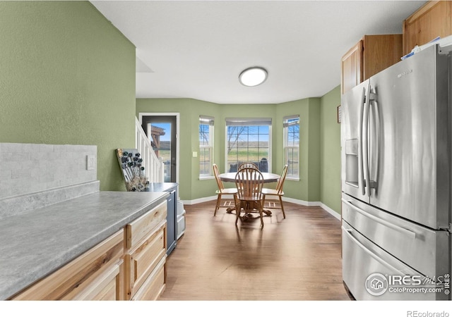 kitchen with wood-type flooring and stainless steel fridge with ice dispenser