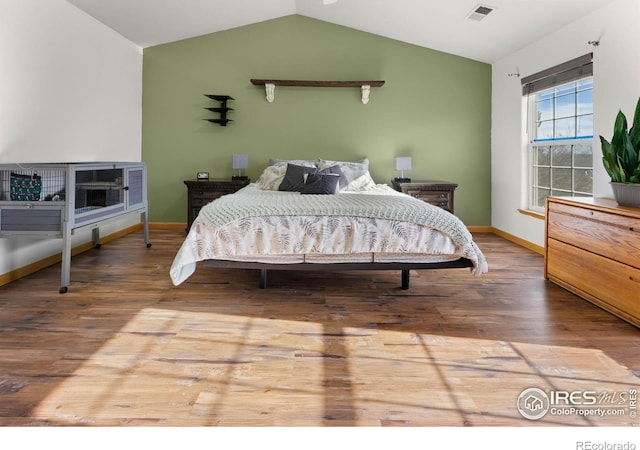 bedroom with wood-type flooring and lofted ceiling