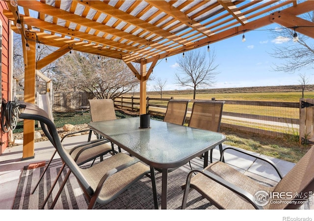 view of patio / terrace with a pergola and a rural view