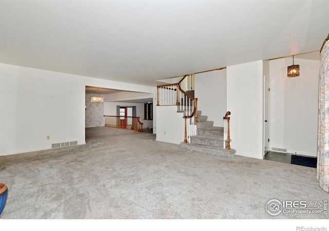 unfurnished living room with carpet and a chandelier