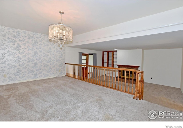 empty room with carpet and an inviting chandelier