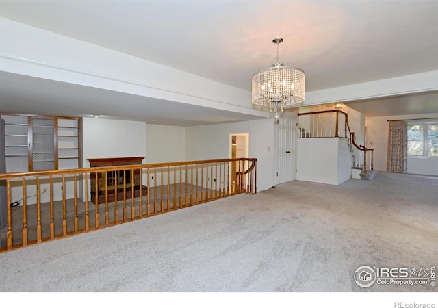 carpeted empty room featuring a chandelier