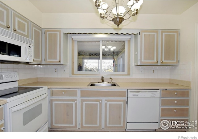 kitchen with backsplash, sink, a chandelier, and white appliances