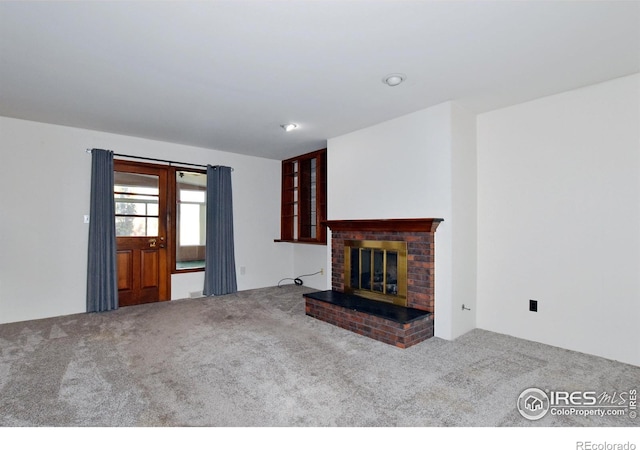 unfurnished living room with carpet floors and a brick fireplace