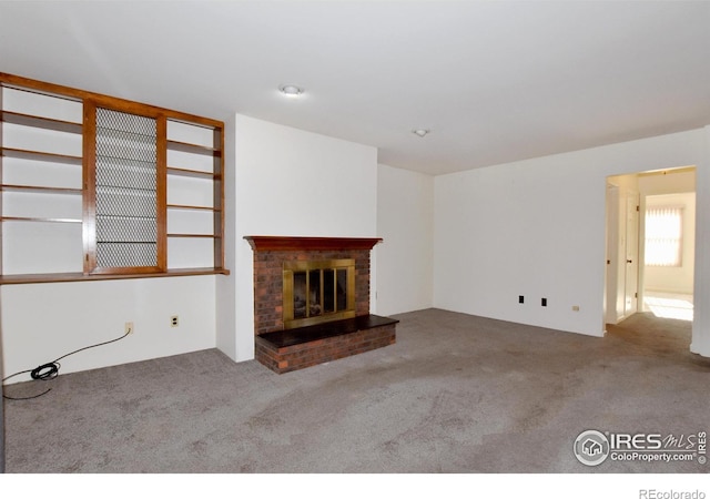 unfurnished living room with carpet and a fireplace