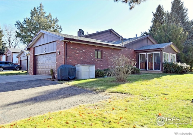 exterior space with a sunroom, a yard, and a garage