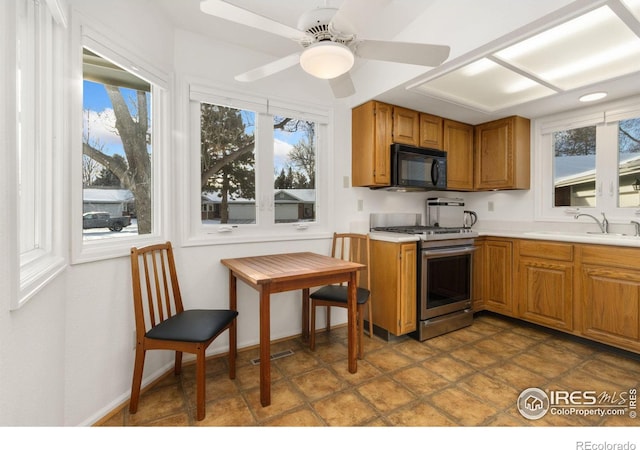 kitchen featuring plenty of natural light, stainless steel range with gas stovetop, and sink