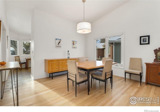 dining space with lofted ceiling and light hardwood / wood-style floors