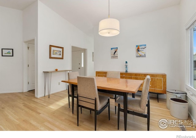 dining area with high vaulted ceiling, a healthy amount of sunlight, and light wood-type flooring