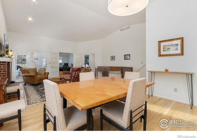 dining area featuring lofted ceiling and light hardwood / wood-style flooring