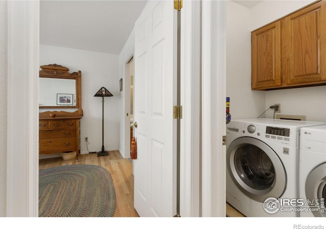 washroom featuring cabinets, separate washer and dryer, and light wood-type flooring