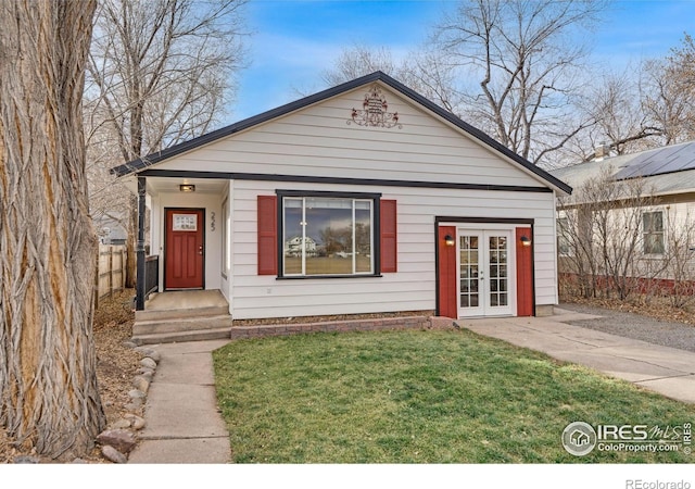 view of front of house with french doors and a front lawn