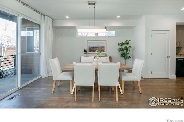 dining room with dark hardwood / wood-style flooring and a wealth of natural light