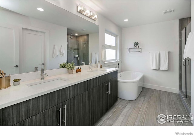 bathroom featuring shower with separate bathtub, vanity, and hardwood / wood-style flooring