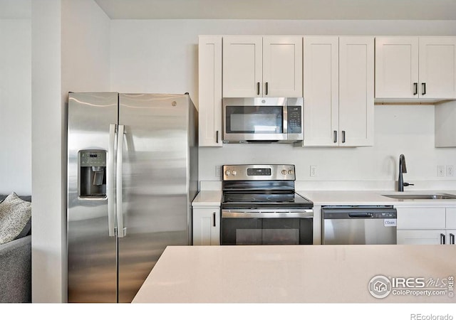 kitchen with white cabinetry, sink, and appliances with stainless steel finishes