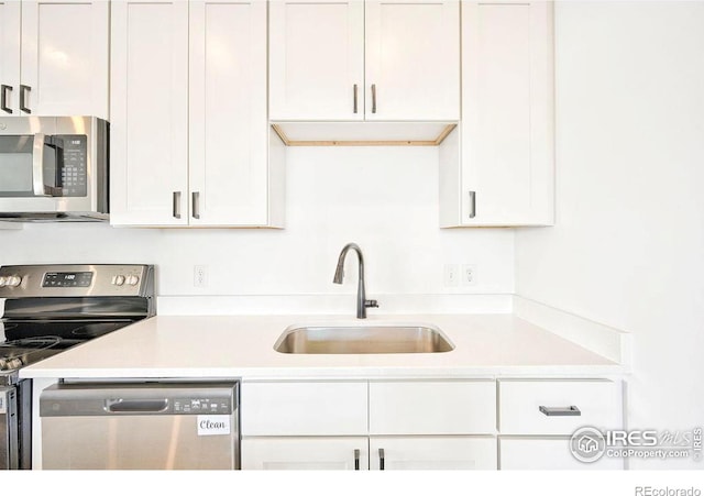 kitchen with white cabinets, stainless steel appliances, and sink