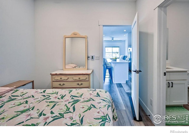 bedroom featuring connected bathroom and dark hardwood / wood-style flooring