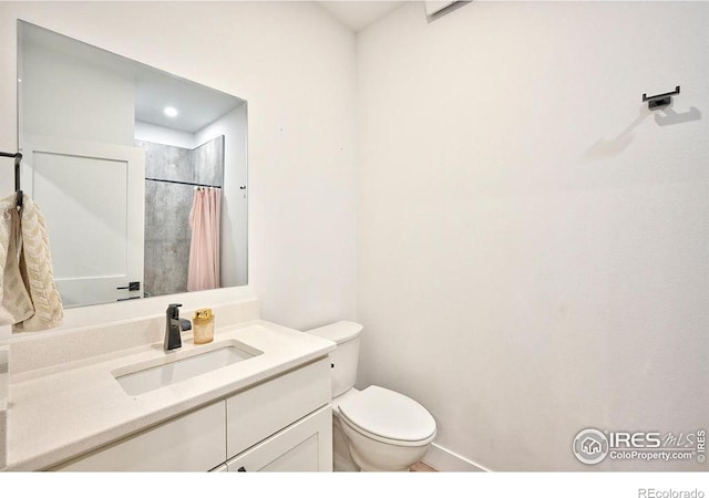 bathroom with vanity, a shower with shower curtain, and toilet